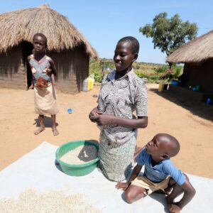 Three people in a Ugandan village